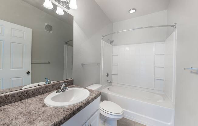 bathroom with white cabinets, bathtub and shower with built-in shelves