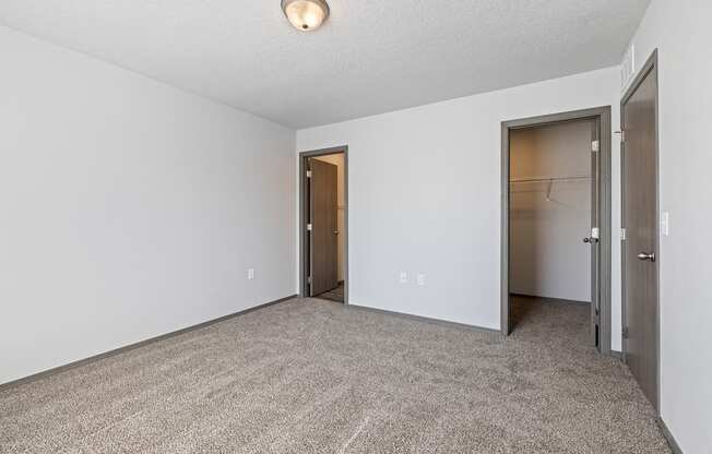 Bright, vacant bedroom with neutral walls and carpet flooring.