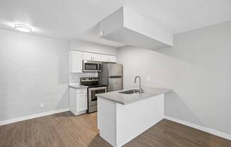 A kitchen with white cabinets and a white island.