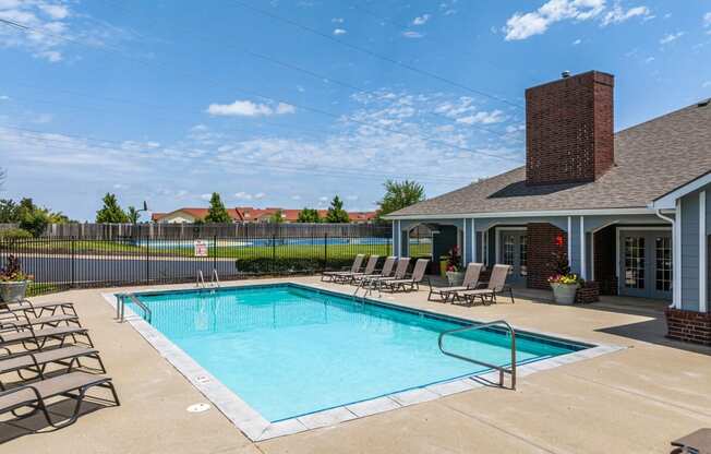 our resort style swimming pool is in front of our house with lounge chairs