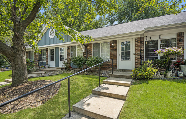 a house with stairs and a tree in front of it