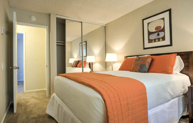 Bedroom with mirrored closet doors, full size bed and night stand at Pacific Sands, San Diego, California