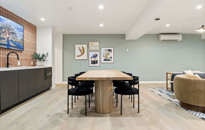 a dining room with a wooden table and black chairs