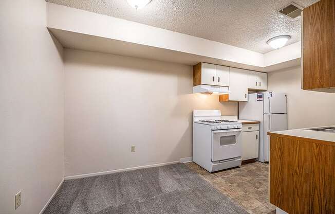 A kitchen with white appliances and a dining room at Seville Apartments, Michigan