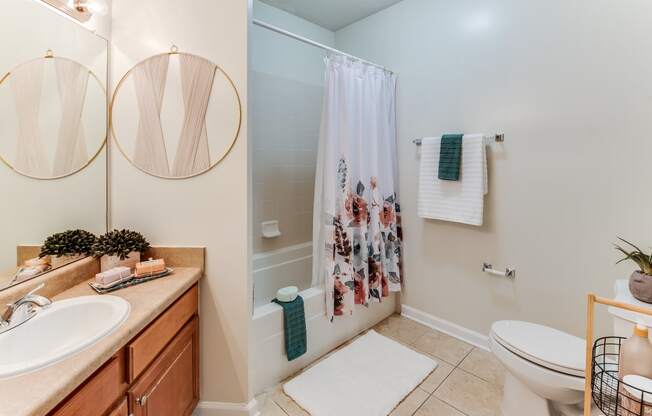 a bathroom with a white sink and toilet next to a shower with a shower curtain
