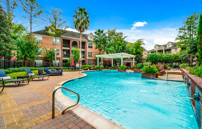A swimming pool surrounded by a brick patio and a building in the background.