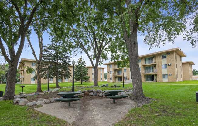 a park with picnic tables in front of an apartment building