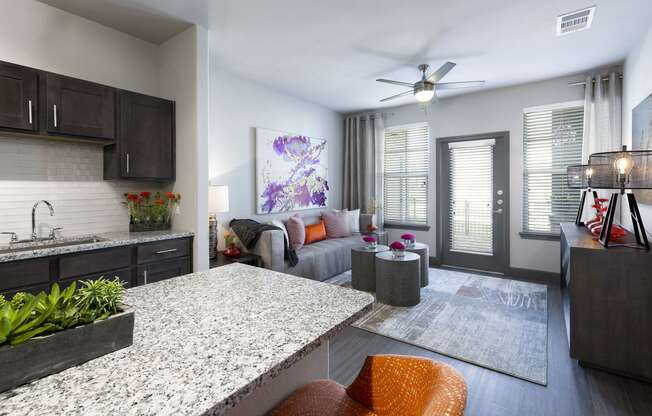 an open living room and kitchen with a granite counter top