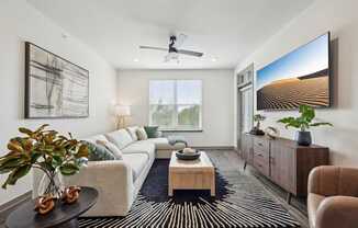 a living room with a white couch and a large window at The Quarry Luxury Apartment Homes, Fort Collins, CO