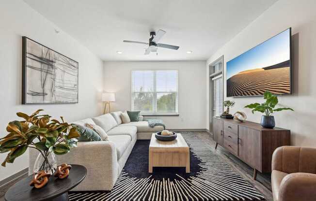 a living room with a white couch and a large window at The Quarry Luxury Apartment Homes, Fort Collins, CO