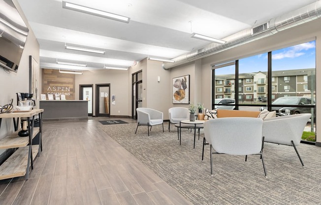 A spacious waiting area with white chairs and a wooden floor.