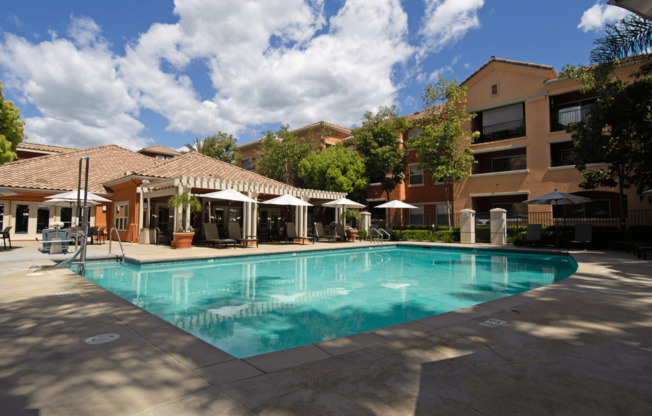 A large swimming pool surrounded by buildings and trees.
