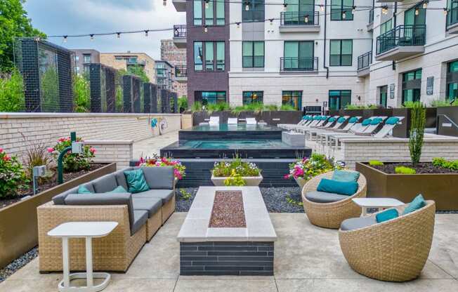 a patio with couches and chairs and a pool in the middle of a building
