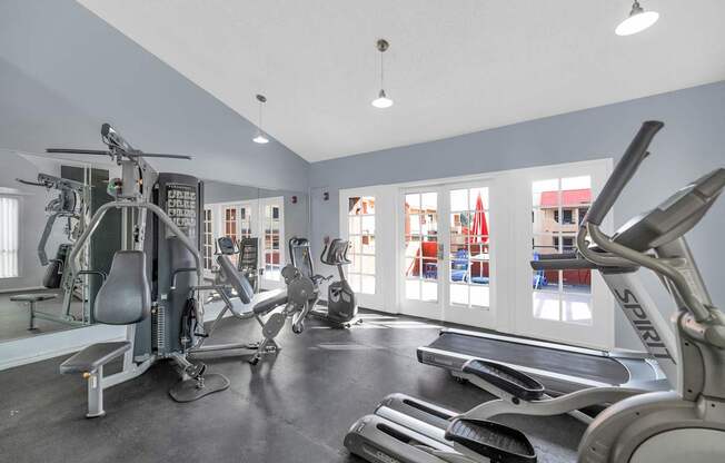 A gym with a variety of equipment including treadmills, stationary bikes, and weight machines at Urban WalkApartments on 6th Avenue, Phoenix 85016