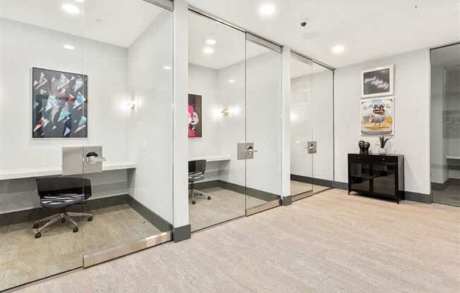 A modern office space with a glass wall and a wooden floor.