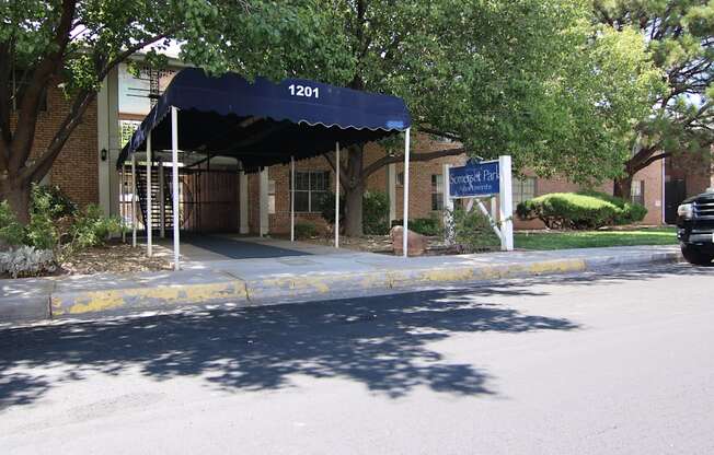 a building with a blue awning in front of a street