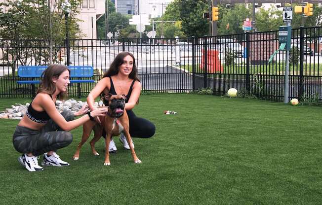 Two residents playing with their dog at the community dog park at The View at Old City, Pennsylvania