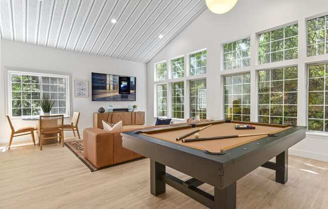 a pool table in the clubroom with windows