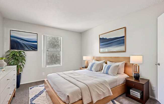 A bedroom with a large bed and a painting on the wall.