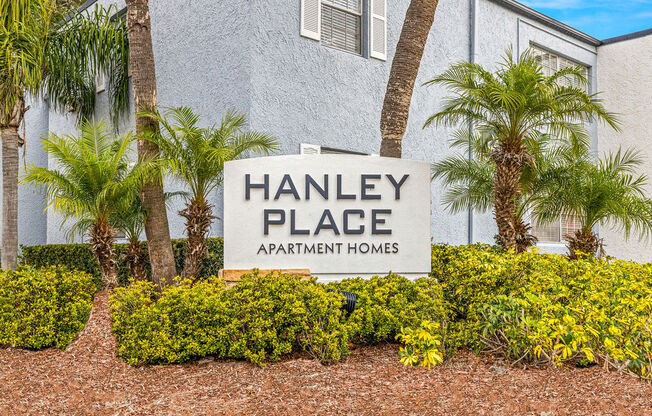 a sign for hanley place apartments in front of palm trees