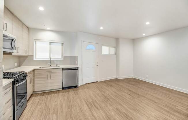 an empty room with a kitchen and a living room