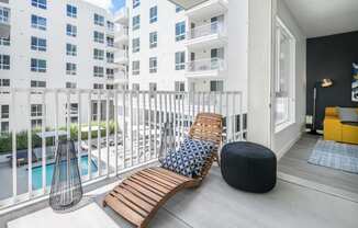 a balcony with two chairs and a bench and a swimming pool at OLiVE DTLA in Los Angeles, California 90015