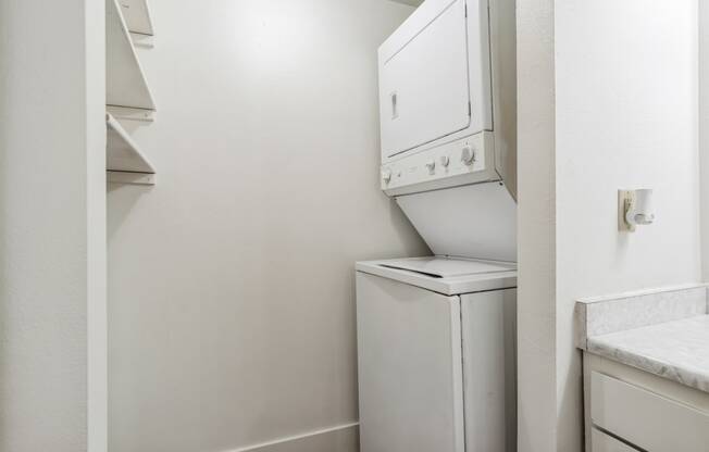 an empty laundry room with a washer and dryer in it