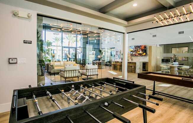 A foosball table is in the middle of a room with a view of the outside.