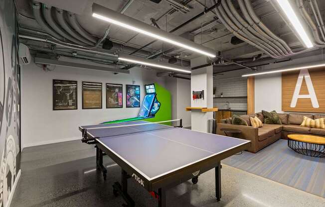 A ping pong table is in the middle of a room with a couch and a TV.