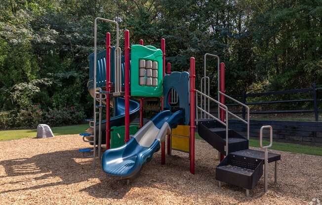 A playground with a blue slide and a green platform.