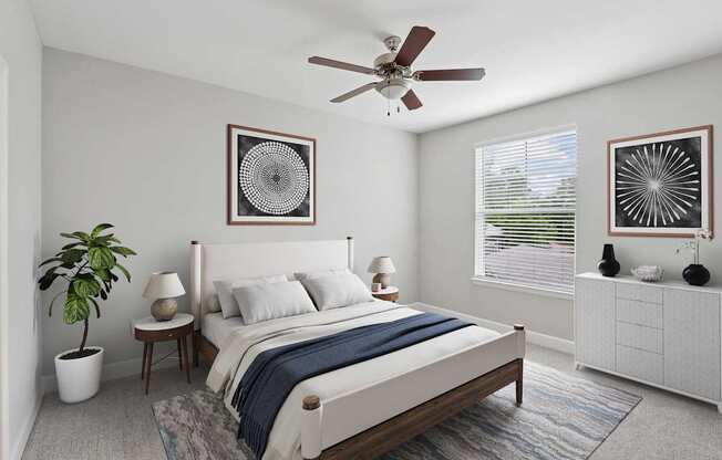 A bedroom with a bed, a ceiling fan, and two wall art pieces.