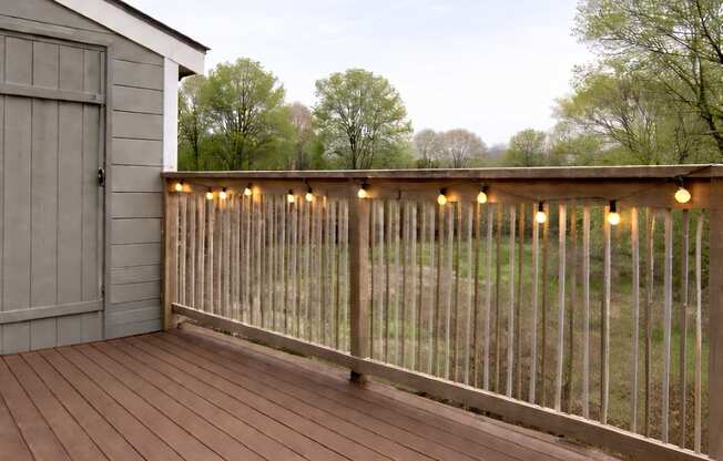 A deck with lights and a shed in the background.
