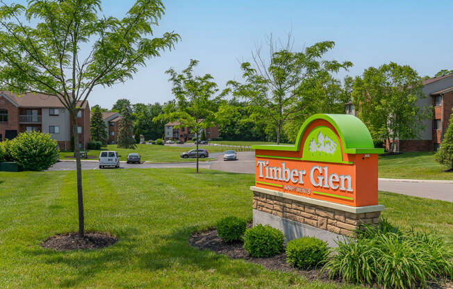 a sign for the thunder glen apartment building with a street in the background