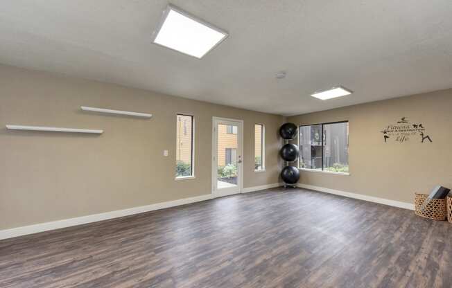 Community Yoga Studio with Hardwood Inspired Floor, Yoga Balls, Large Window and Wicker Basket with Yoga Mats