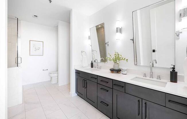 A bathroom with a white sink and a large mirror.