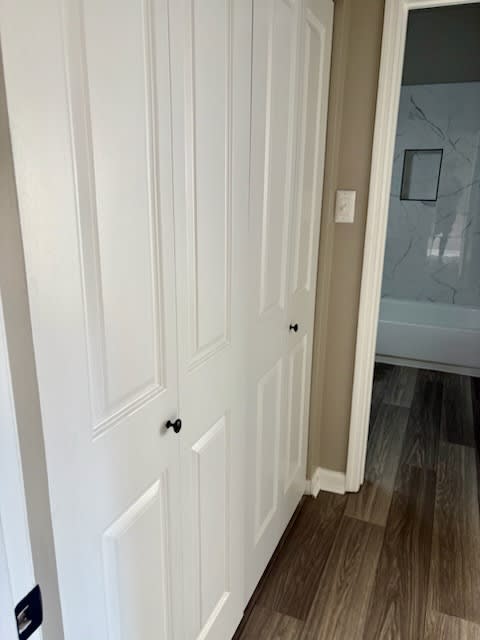A white door with a black handle and a black plate below it.