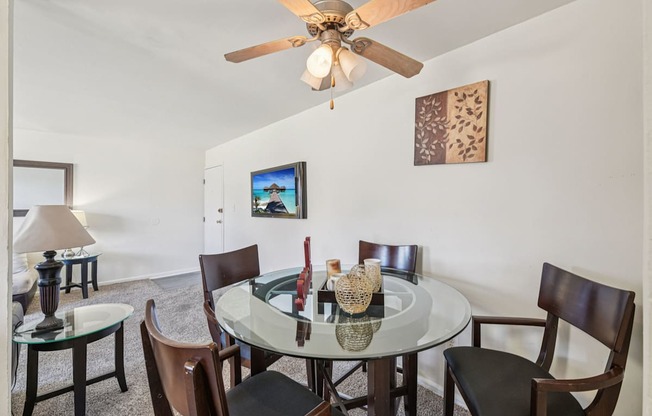 A dining room with a glass table and chairs.