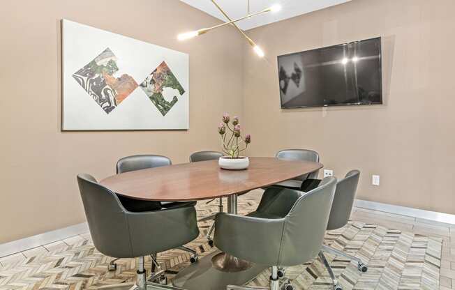 a conference room with a table and chairs and a tv