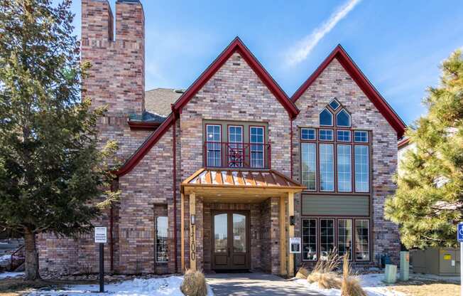 the front of a large brick building with snow on the ground  at The links at Plum Creek Apartments, Castlerock, CO 80104