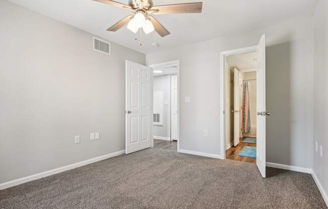 a living room with carpet and a ceiling fan