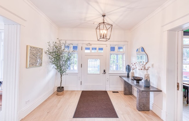 a hallway with white walls and wood floors and a large white door