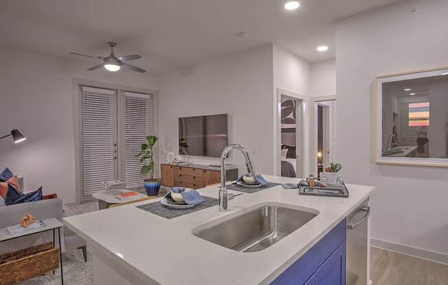 A modern kitchen with a white countertop and blue cabinets.