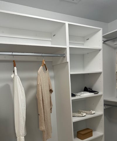 a white closet with two drawers and a towel and an umbrella