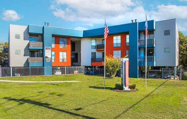 a blue and orange school building with two flags in front of it