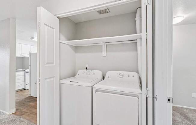 A white washer and dryer are in a small laundry room.