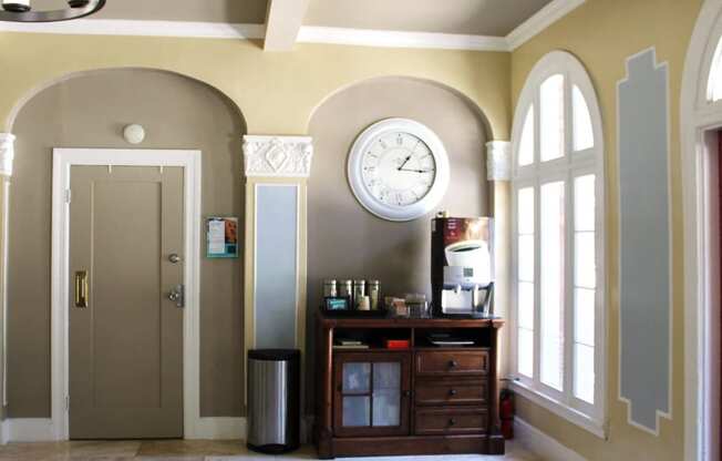 Lobby in Brookmore Apartments in Pasadena with large arched windows and coffee station.