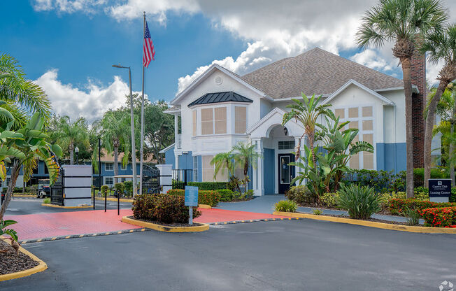 a house with a driveway and an flag inExterior at Captiva Club Apartments at 4401 Club Captiva Drive in Tampa, Florida 33615 front of it