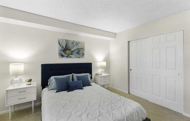a bedroom with a bed and two night stands at Pacific Park Apartment Homes, Edmonds