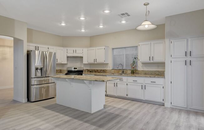 Elegant kitchen open to family room with fireplace.