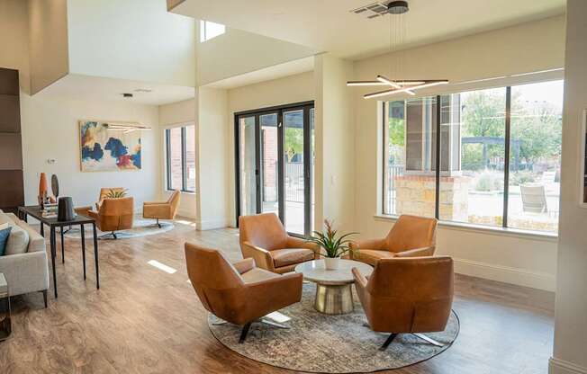 a living room with chairs and a table and sliding glass doors